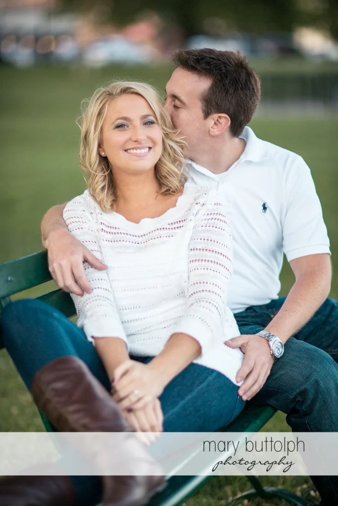 Couple sit on a bench in the garden at Skaneateles Engagement