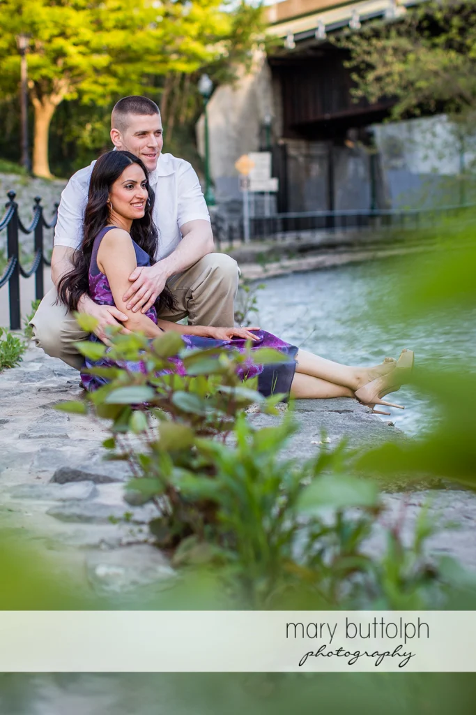 Couple relax near the lake at Franklin Square Engagement