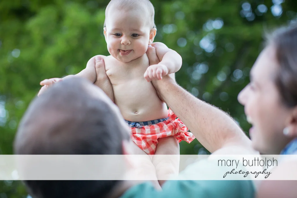 Baby shows her tongue to her parents at Skaneateles Family