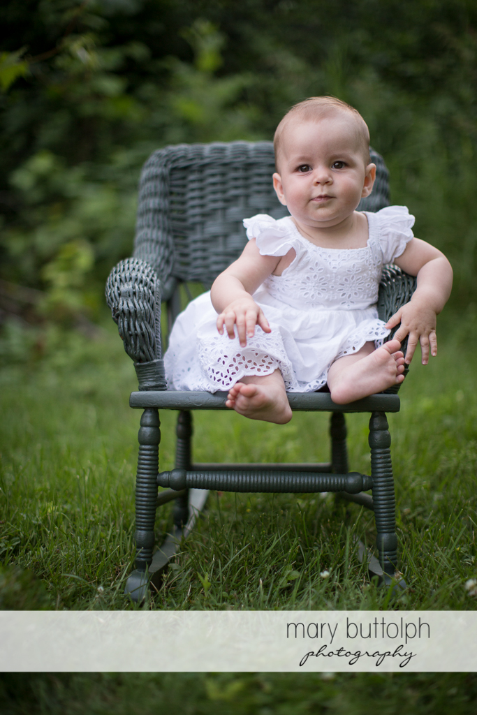 Baby sits on a chair in the backyard at Skaneateles Family