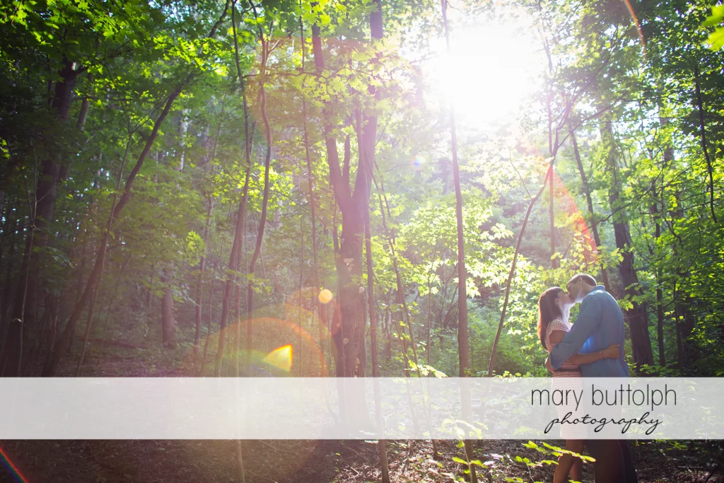 Couple kiss in the woods at Skaneateles Lodge at Welch Allyn Engagement