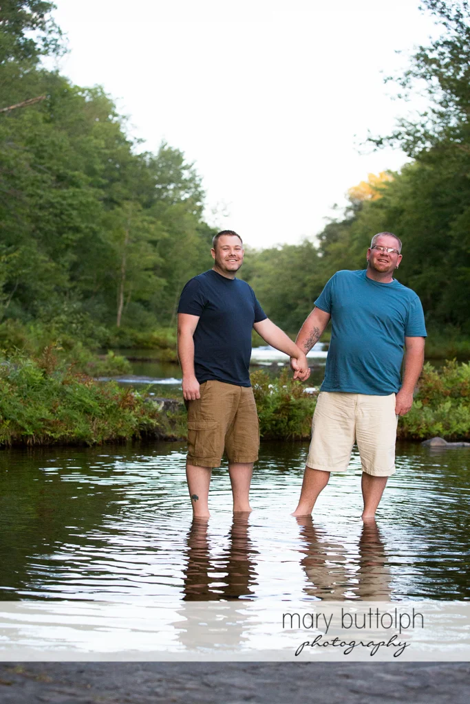 Same sex couple wade in the river at Salmon River Falls Engagement