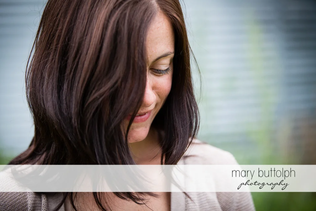 Close up shot of woman with her face partly covered by hair at Skaneateles Farm Engagement