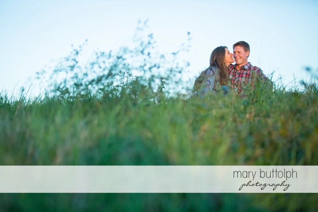 Couple relax in the field at Aurora Engagement
