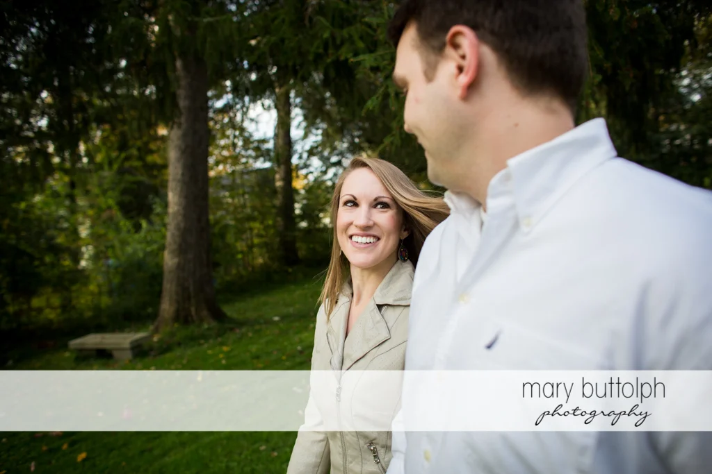 Couple stroll in the woods at Skaneateles Engagement