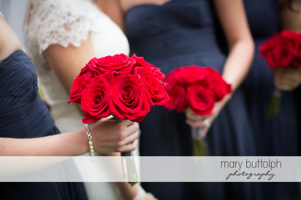 Bride and bridesmaids holding roses at Traditions at the Links Wedding