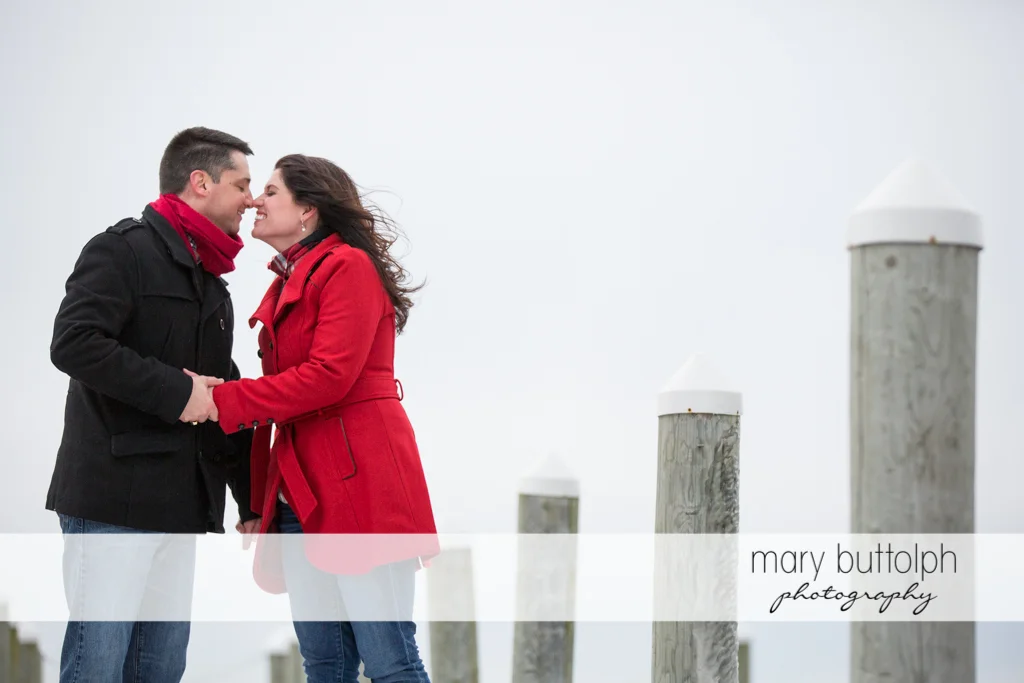 Couple rub noses at the dock at the Aurora Inn Engagement