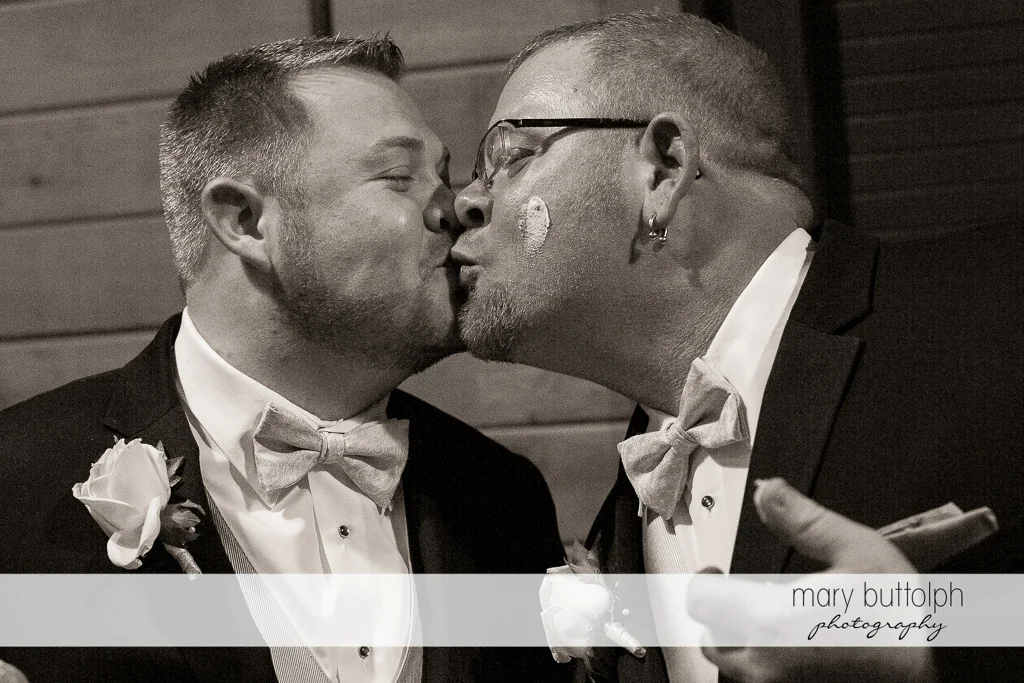 Same sex couple kiss after having cake at Arrowhead Lodge Wedding