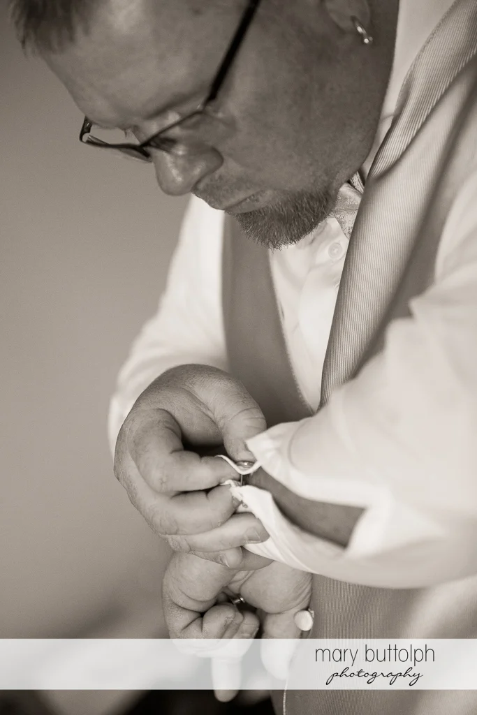 Groom buttons his shirt at Arrowhead Lodge Wedding