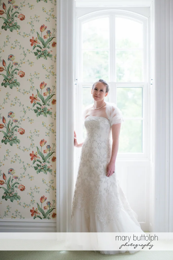 Bride poses by the window at the Inns of Aurora Wedding