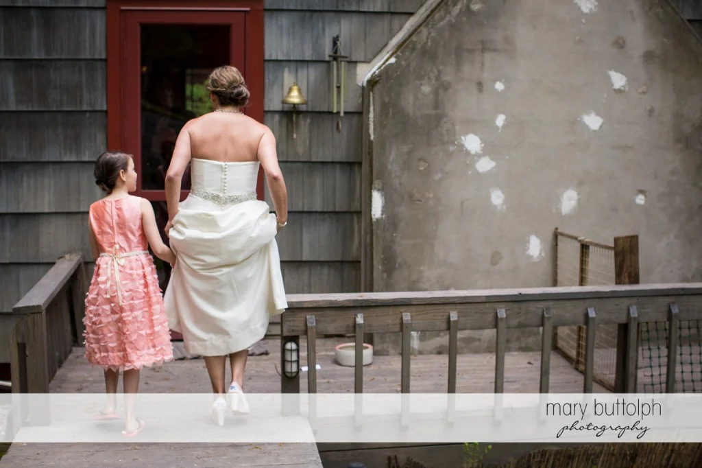 Bride and young girl make their way to a door at Skaneateles Country Club Wedding