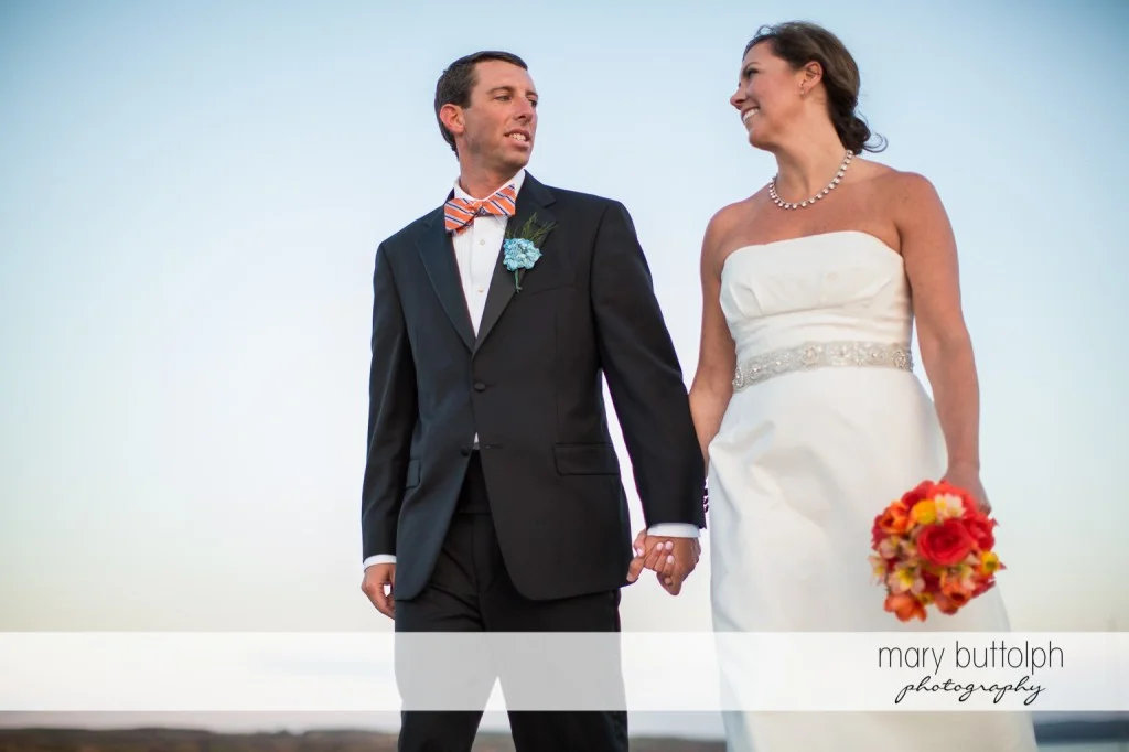 Couple hold hands by the lake at Skaneateles Country Club Wedding
