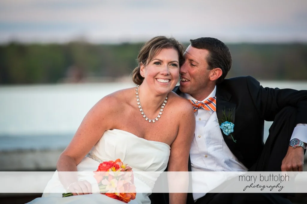 Groom whispers to the smiling bride at Skaneateles Country Club Wedding