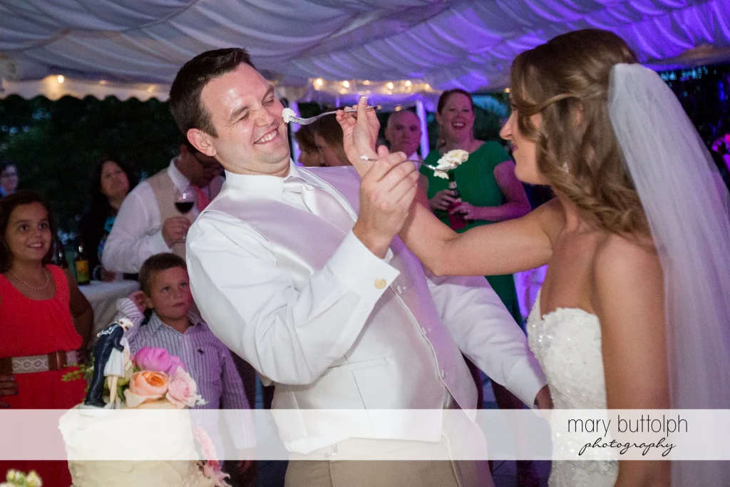 Couple try their wedding cake at the Inns of Aurora Wedding