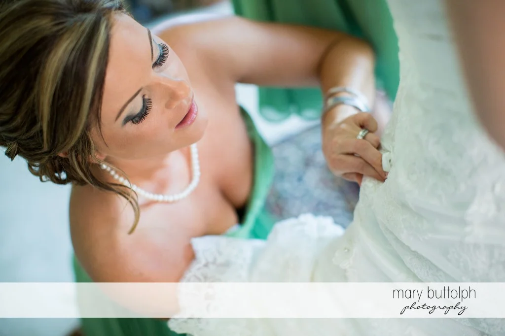 Bridesmaid fixes the bride's wedding dress at Emerson Park Pavilion Wedding