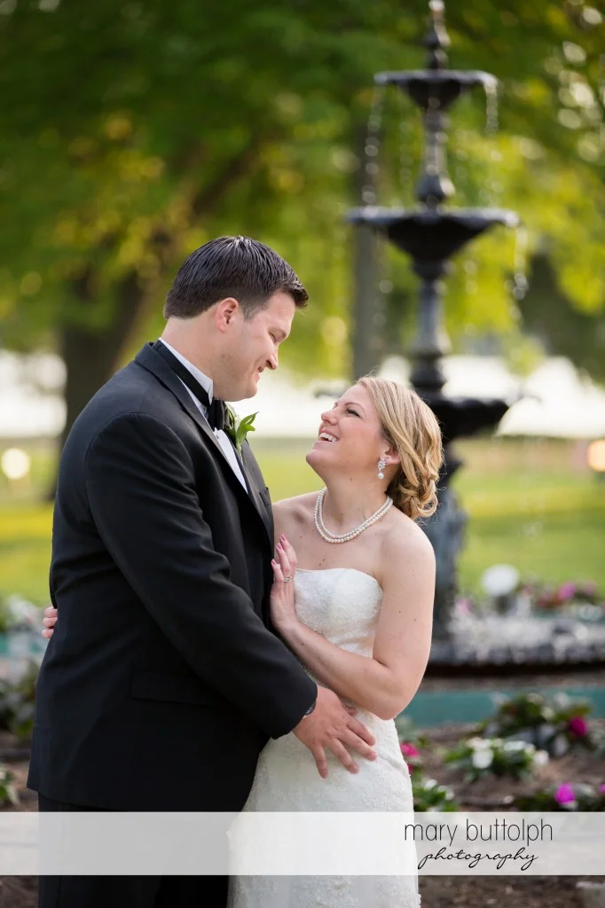 Couple pose in front of the fountain at Emerson Park Pavilion Wedding