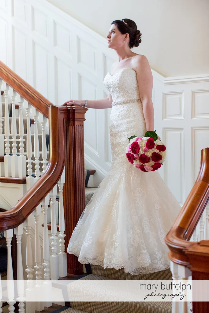 Bride with bouquet goes downstairs to meet the groom at the Inns of Aurora Wedding