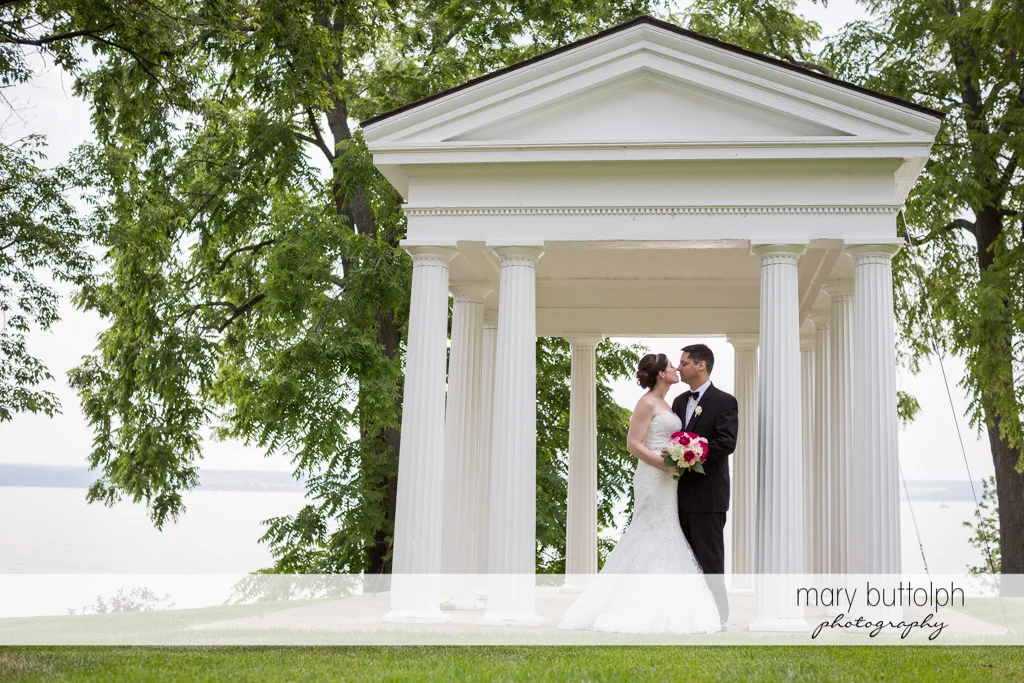 Couple rubs noses near the lake at the Inns of Aurora Wedding