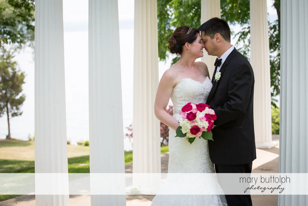 Couple rub noses under the gazebo at the Inns of Aurora Wedding