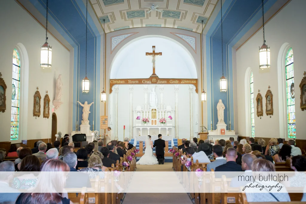 Long shot of the couple and guests in church at the Inns of Aurora Wedding