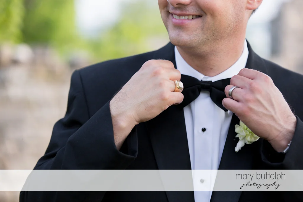The groom fixes his tie at the Inns of Aurora Wedding