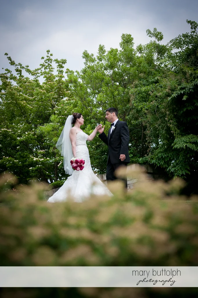 Couple hold hands in the garden at the Inns of Aurora Wedding