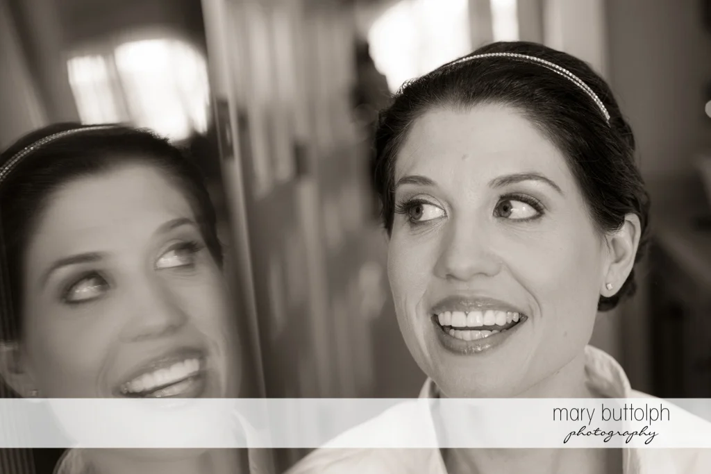 Bride's happy reflection in the mirror at the Inns of Aurora Wedding
