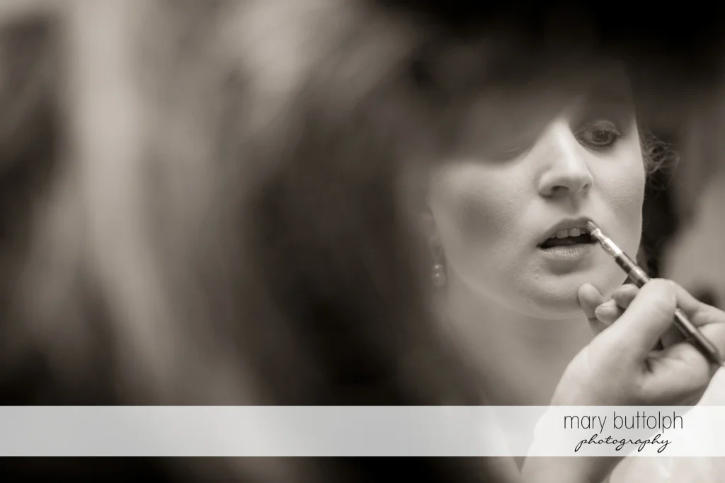 Bride uses lip gloss at the Mirbeau Inn & Spa Wedding