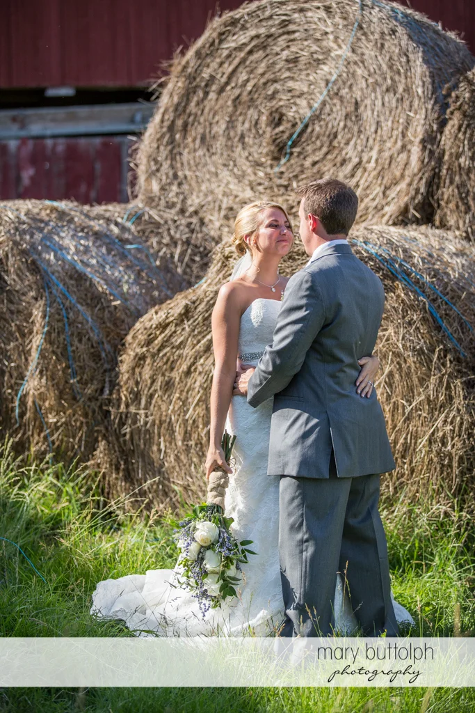 Couple pose in front of haystacks at the Sherwood Inn Wedding
