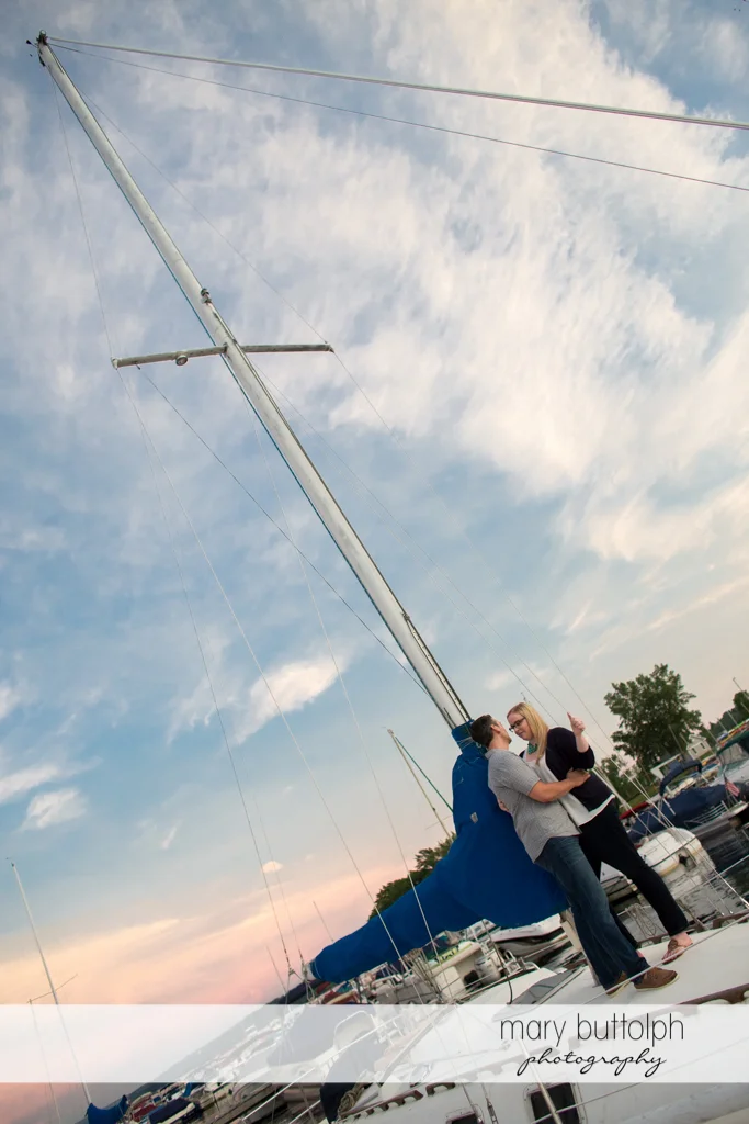 Couple board one of the sailboats at the lake at Skaneateles Engagement