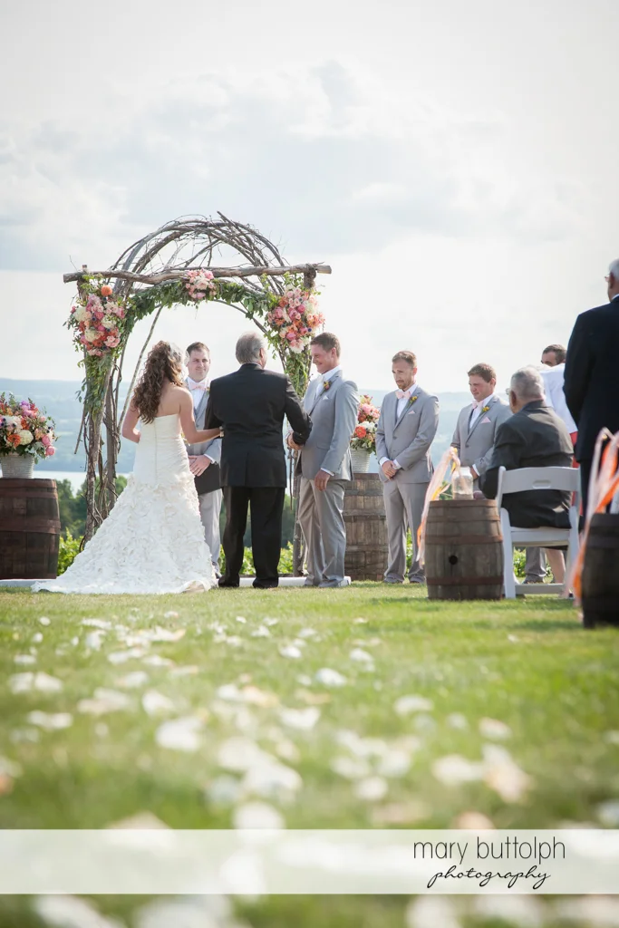Bride's father shakes the groom's hand during the garden wedding at the Inns of Aurora Wedding