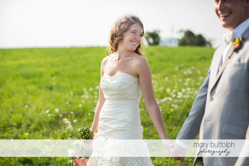 Couple hold hands in the garden at the Inns of Aurora Inn Wedding