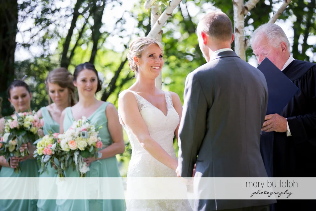 Bride faces the groom in the garden at Arrowhead Lodge Wedding