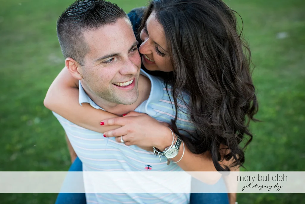 Man gives woman a piggyback ride in the garden at Skaneateles Country Club Engagement