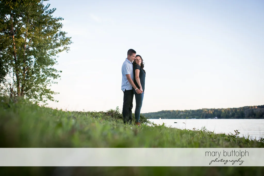 Couple stand near the lake at Skaneateles Country Club Engagement