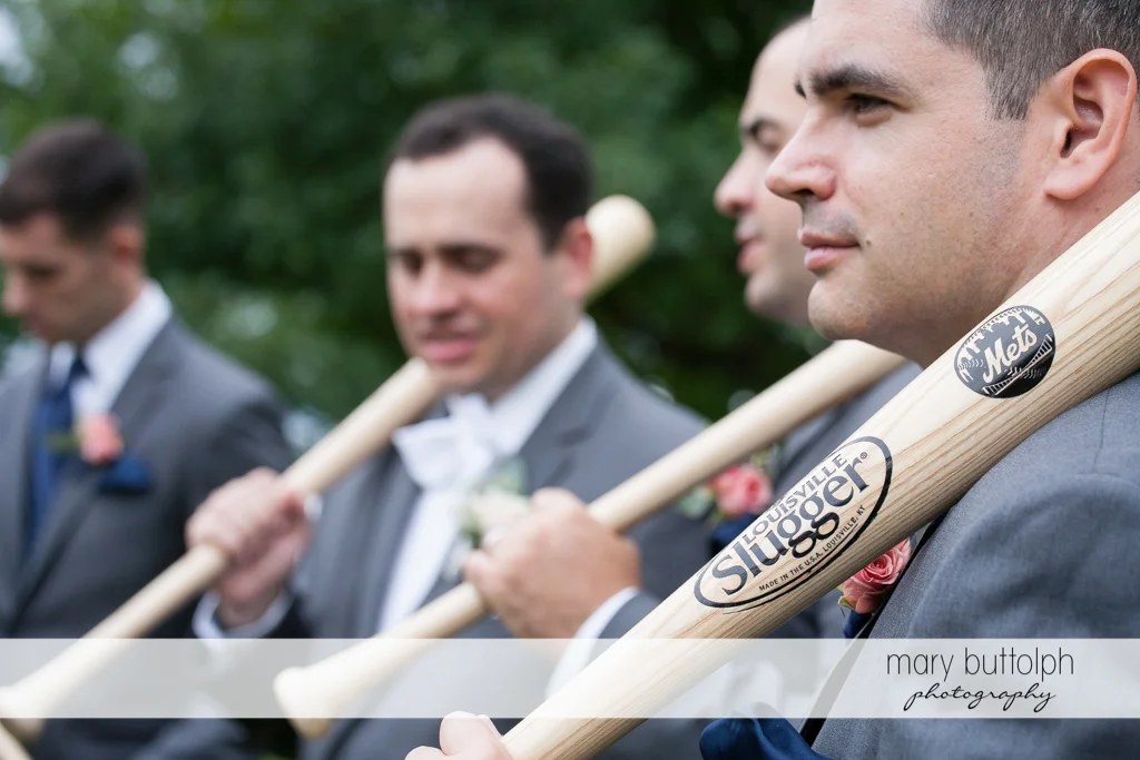Groom and his groomsmen hold baseball bats at the Inns of Aurora Wedding