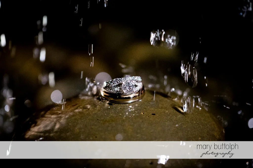 Rain falls on the couple's wedding rings at the Inns of Aurora Wedding