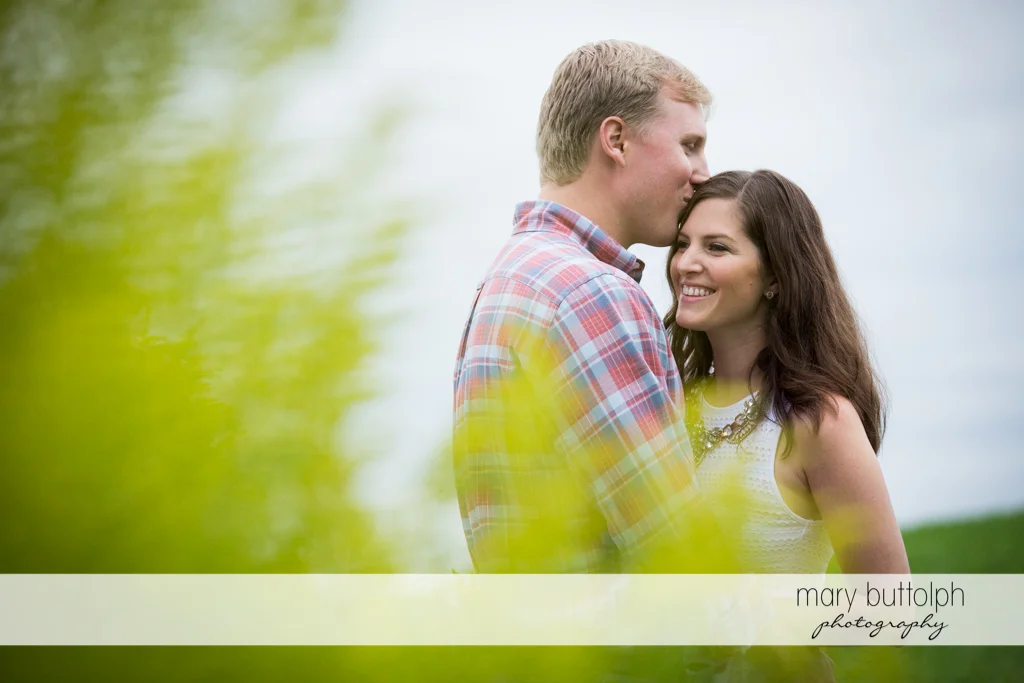 Couple stand near plants at Hobbit Hollow House Engagement