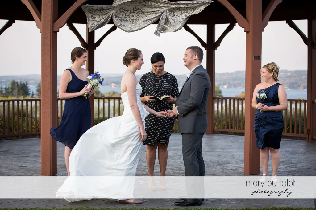 Couple hold hands in front of the wedding officiant at Anyela's Vineyards Wedding