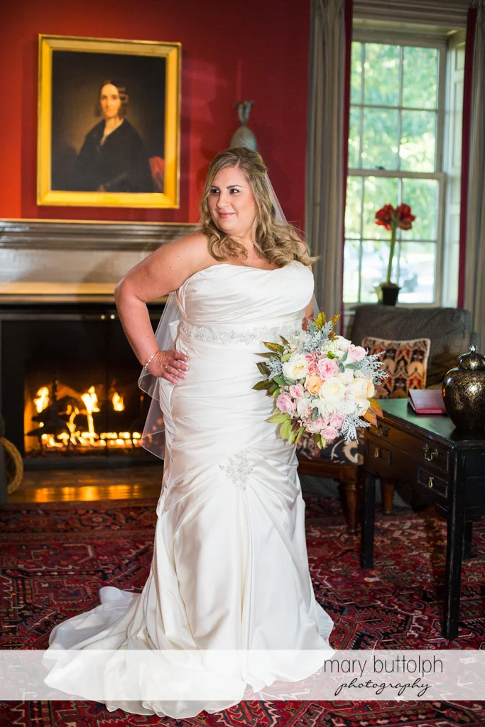 Bride stands in front of the fireplace at the Inns of Aurora Wedding