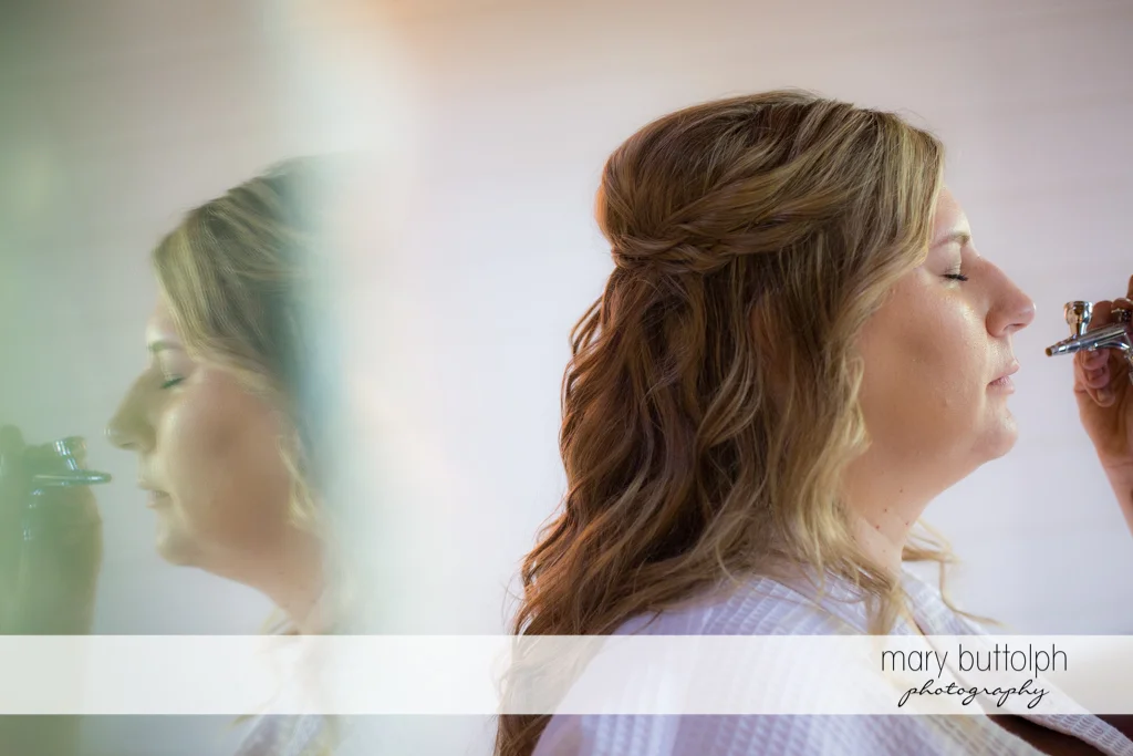 Bride gets a makeover via airbrush makeup at the Inns of Aurora Wedding