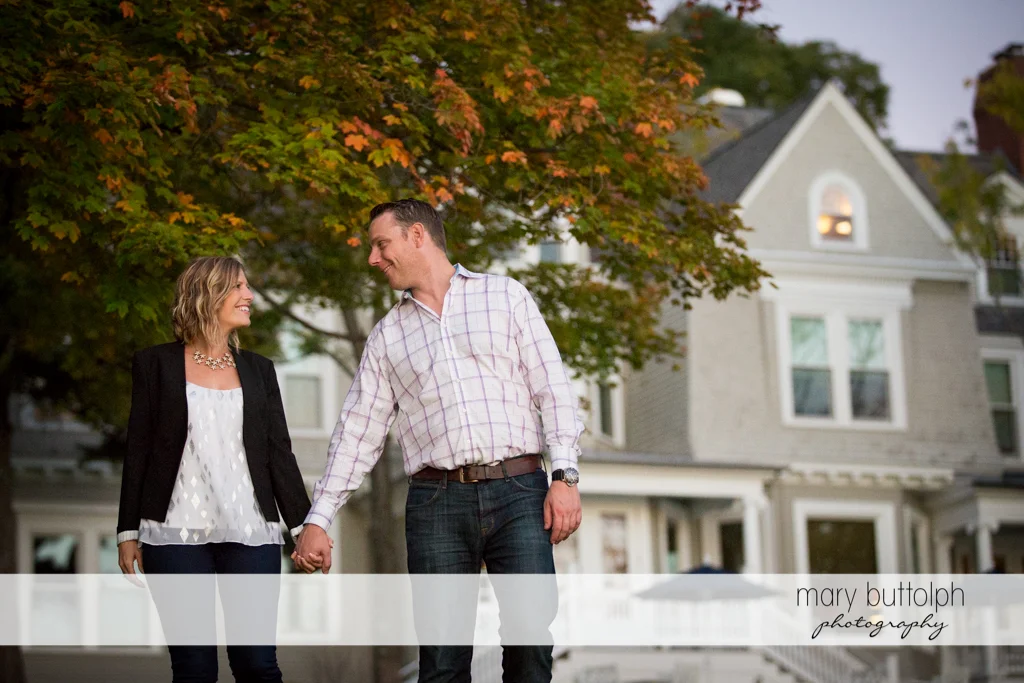 Couple stroll in front of a house at the Inns of Aurora Engagement