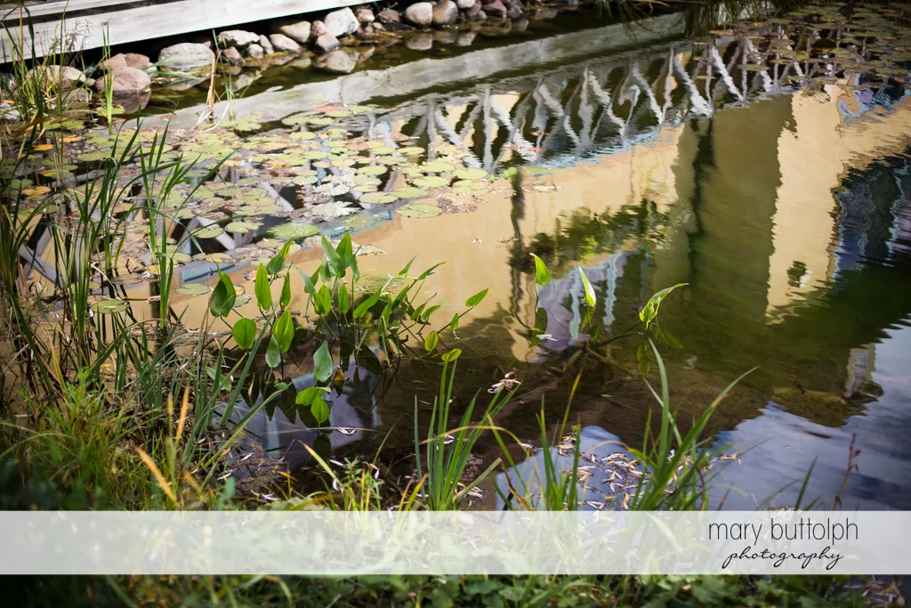 House is reflected on the lake at Skaneateles Country Club Wedding