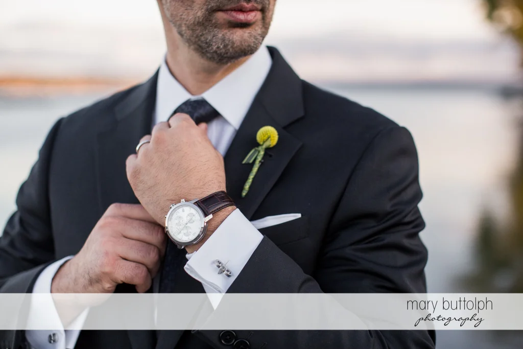 Close up shot of the groom's watch and corsage at Skaneateles Country Club Wedding