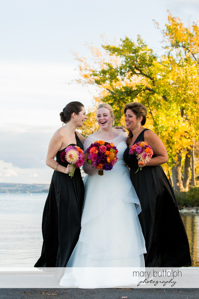 Bride and her bridesmaids near the lake at Skaneateles Country Club Wedding
