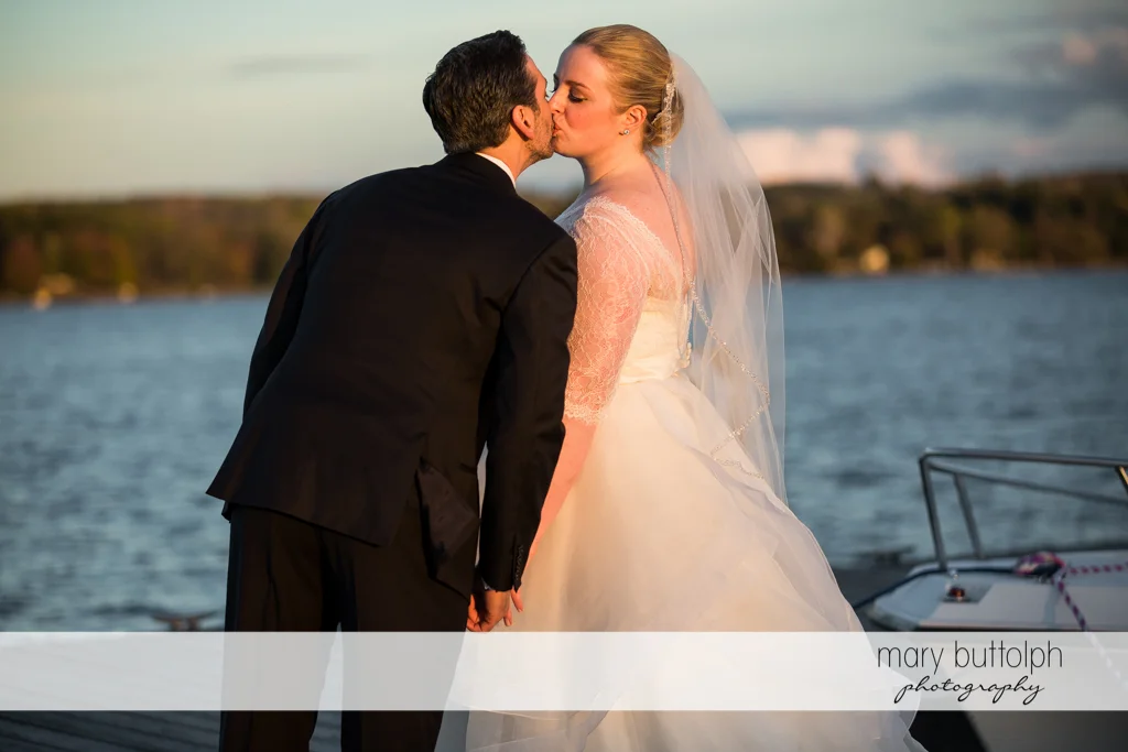 Couple kiss by the lake at Skaneateles Country Club Wedding