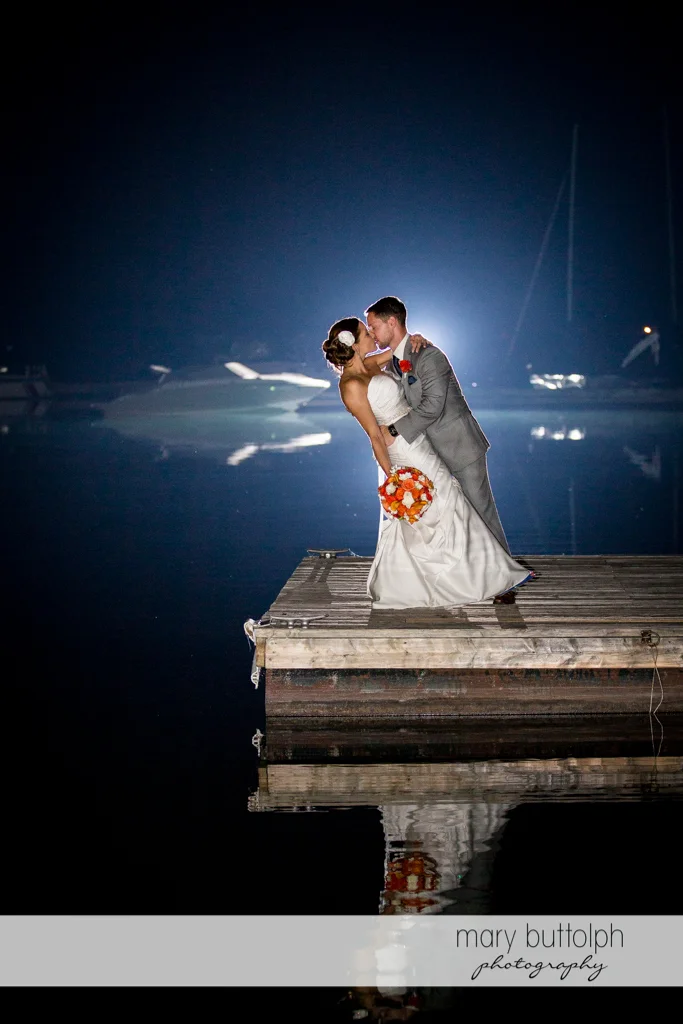 Couple kiss in the moonlight on the docks at Skaneateles Country Club Wedding