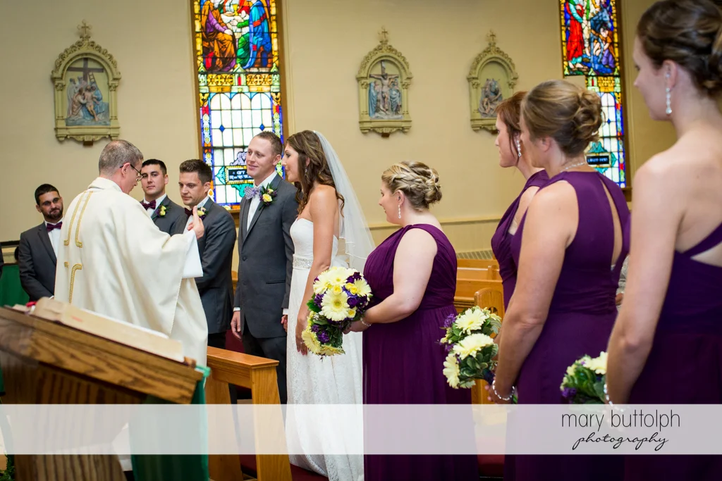 The wedding party face the priest in front of the altar at the Sherwood Inn Wedding