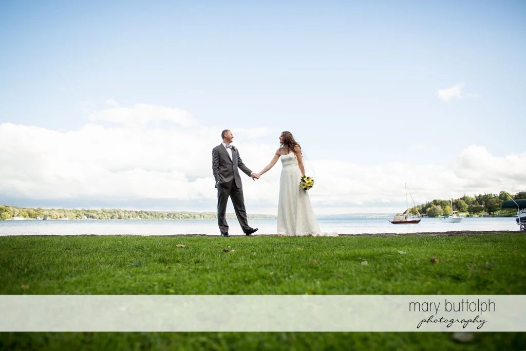 Couple hold hands in front of the lake at the Sherwood Inn Wedding
