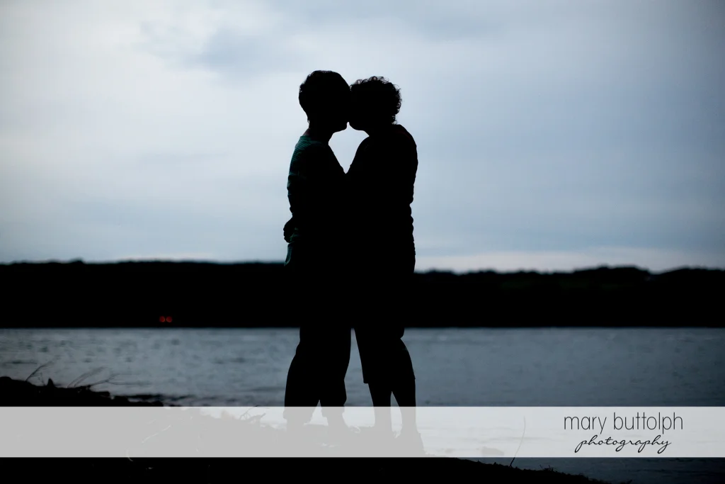 Same sex couple kiss as night approaches at Skaneateles Lake Engagement